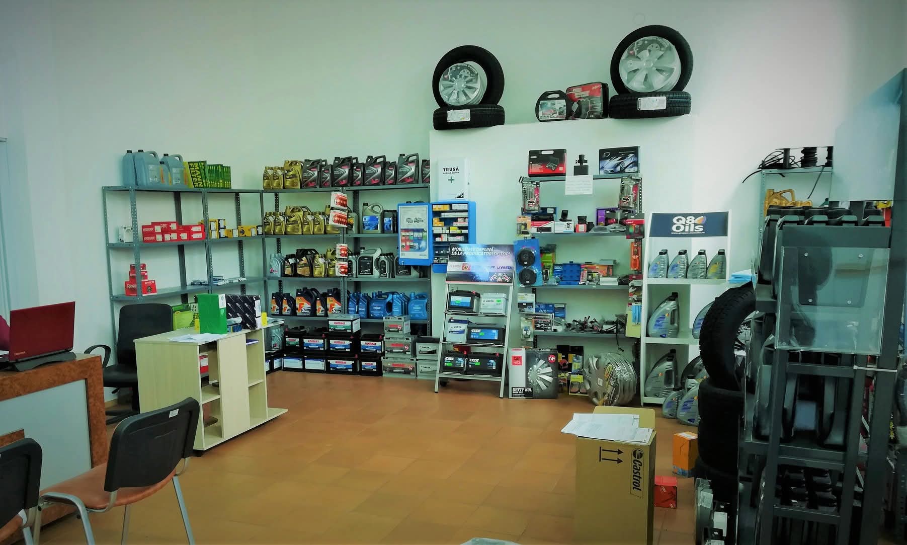Interiorul magazinului — rafturi cu piese, uleiuri și baterii